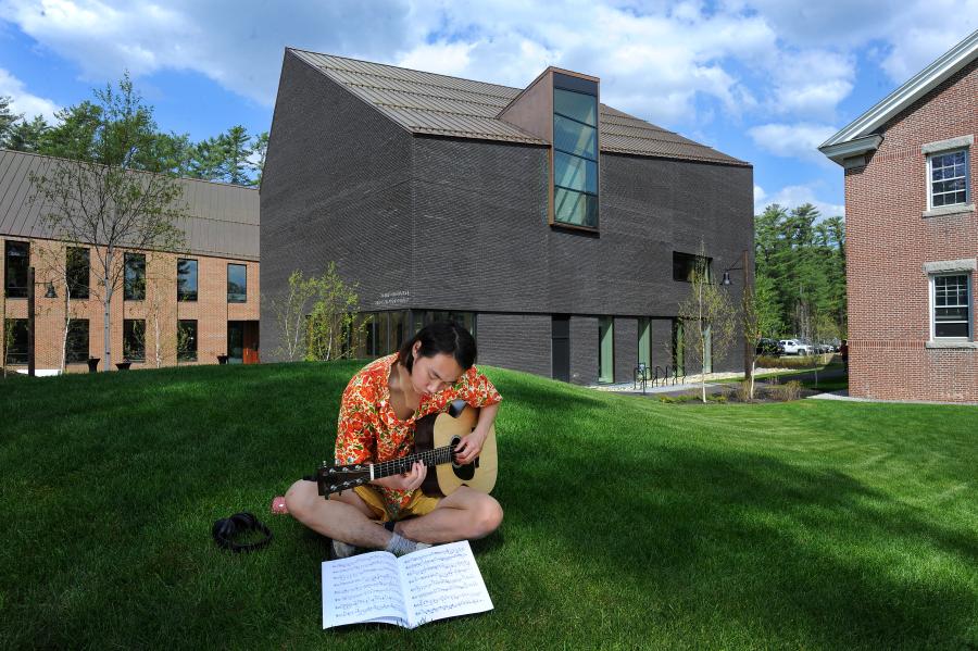 Gibbons Center with student playing guitar in the foreground